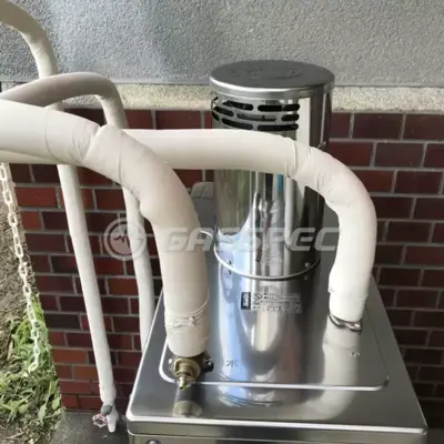 屋外に据え付けた長府製作所の石油給湯器の配管と排気筒