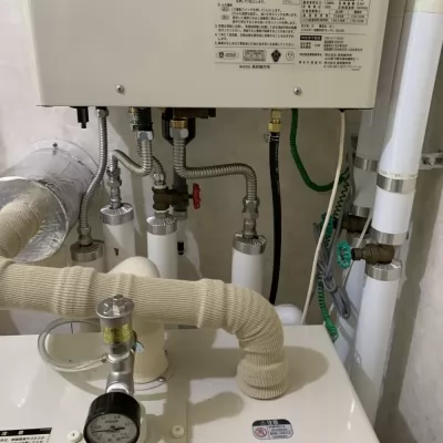 長府製作所のエコフィール本体の下側。給水・給湯配管とドレン配管の接続部分